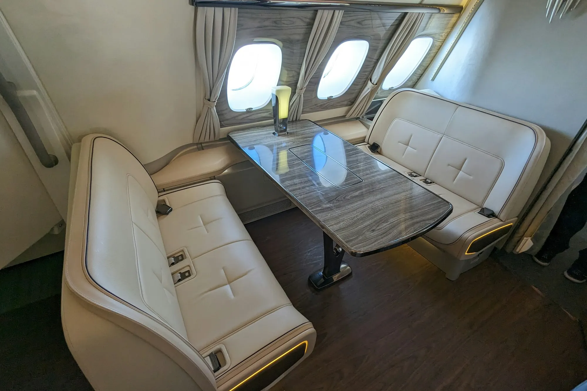 Cream leather club seats facing a table in a small jet cabin